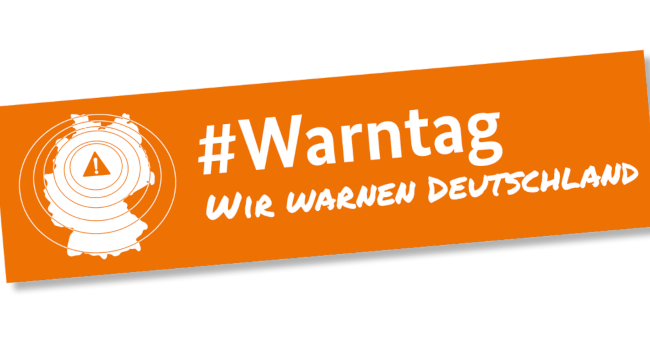 Logo zum bundesweiten Warntag: Ein oranges Schild, im Bildteil die Bundesrepublik mit einem Warnsymbol, im Textteil der Schriftzug 'Warntag 2024. Wir warnen Deutschland.