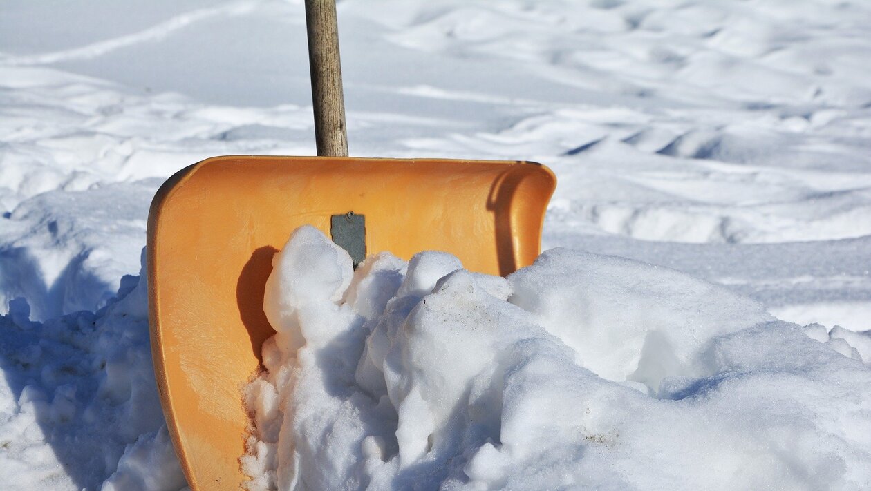 Eine Schneeschaufel steckt in einem Schneehaufen